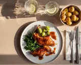Gebratenes Kaninchen mit Rosenkohl, Petersilie und kleinen Kartoffeln, serviert mit Zitronenwasser.