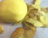 Ein geschältes Kartoffelstück liegt neben einem Haufen Kartoffelschalen, die wie ein kleines, flauschiges Kaninchen aussehen.
